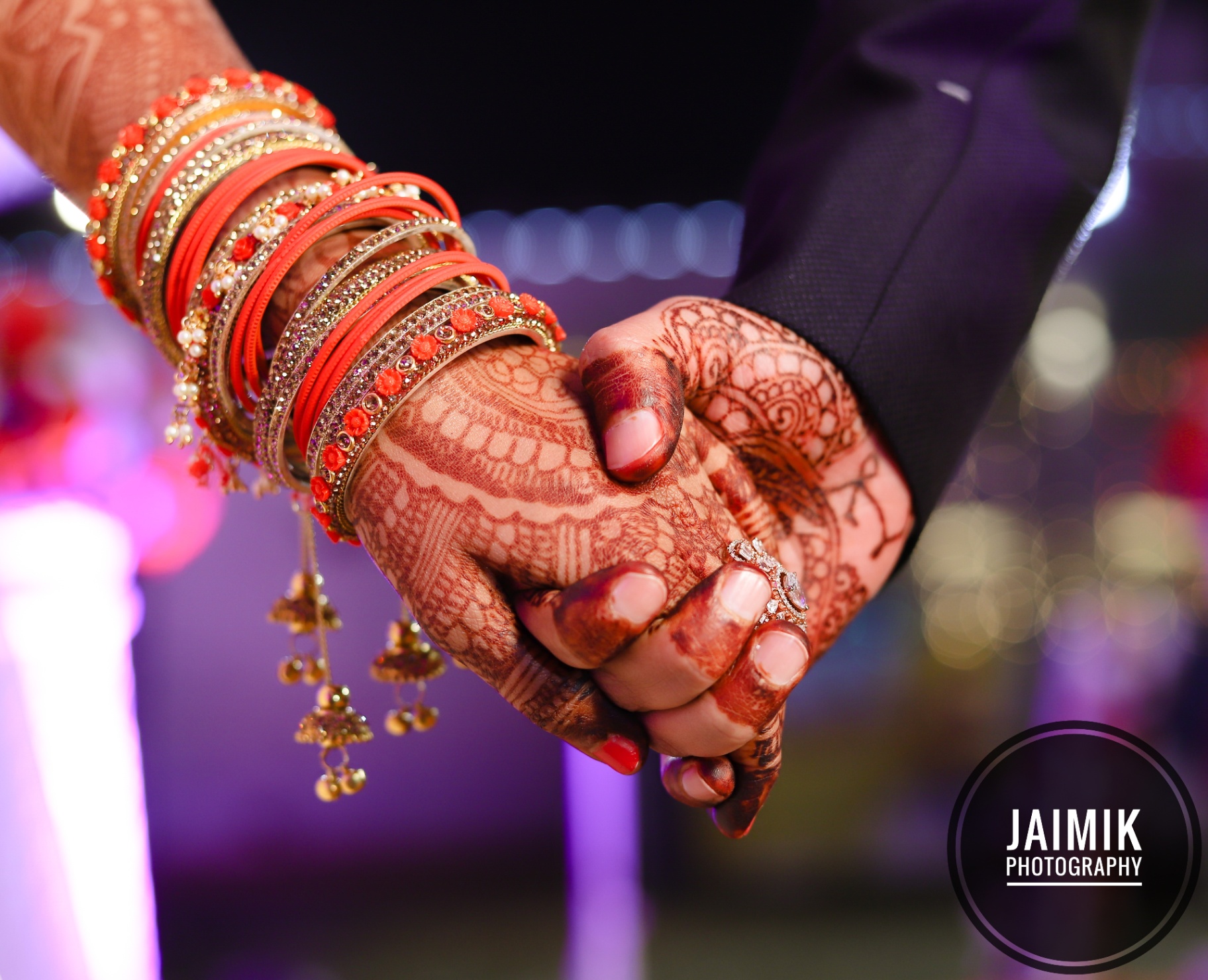 Hennaed hands of a bride and groom held together