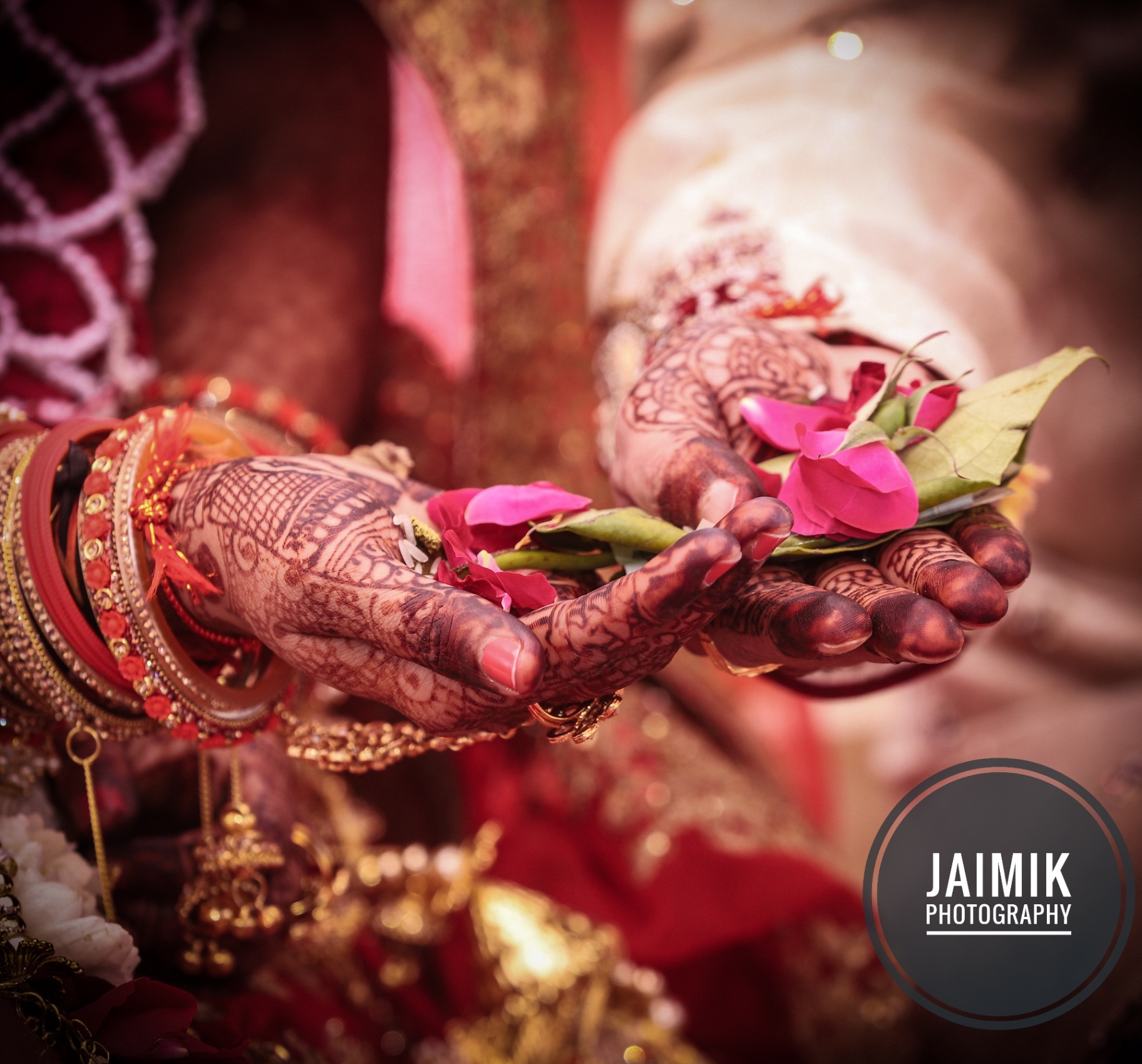 Bride's hennaed hands holding flowers during a ritual